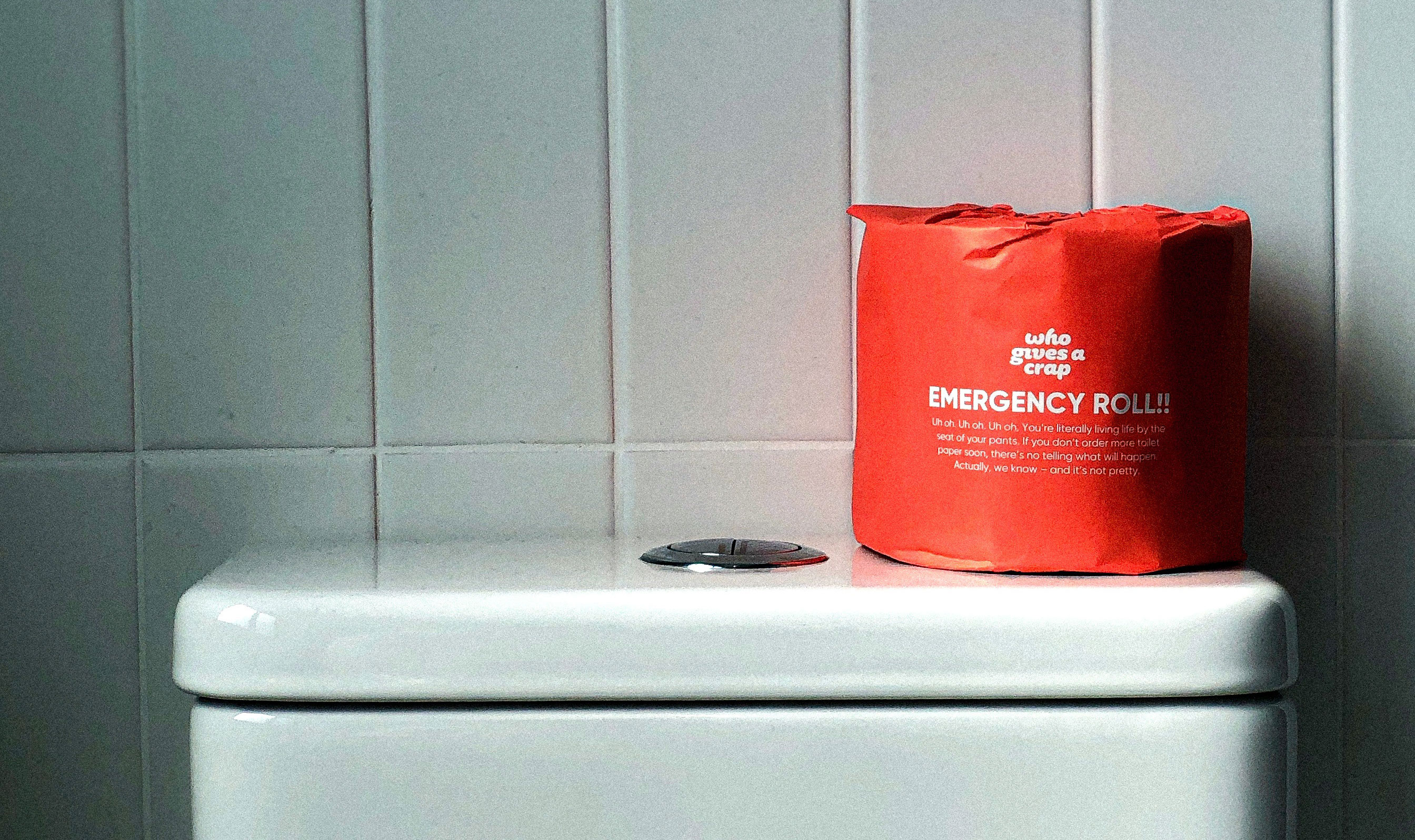 A roll of red toilet paper is placed on top of the toilet tank, indicating ease of defecation and relief from constipation.