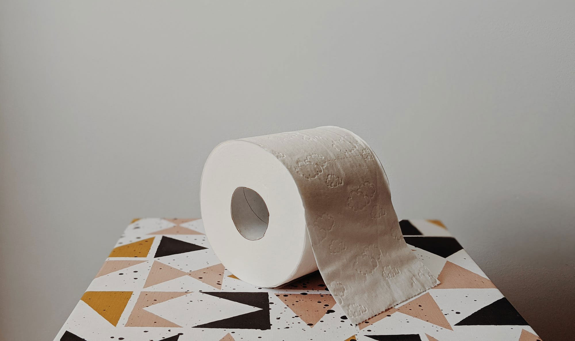 A toilet paper roll is positioned on the toilet bowl to suggest constipation.