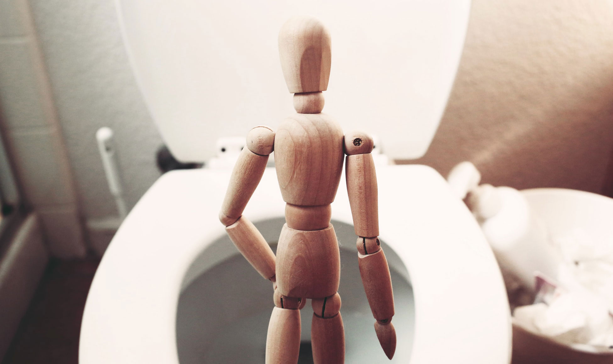 A figure staying in front of the toilet bowel feeling stuck suggesting constipation.