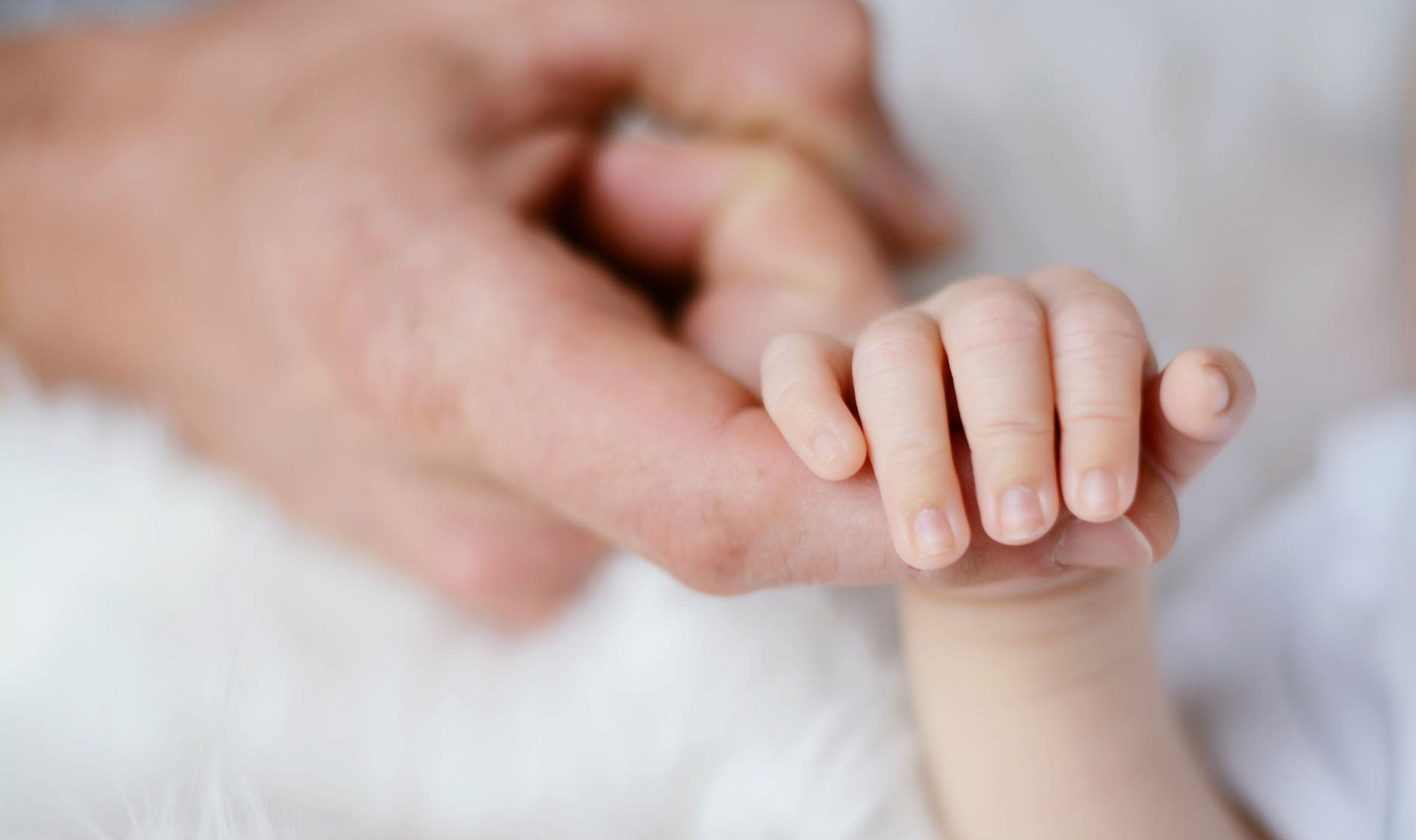doctor holding the hand of an infant with constipation