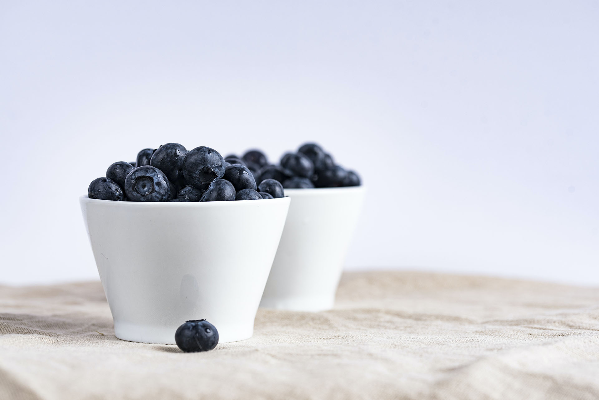 Two small cups are holding fruit inside that are suggesting quick relief and a healthy diet.